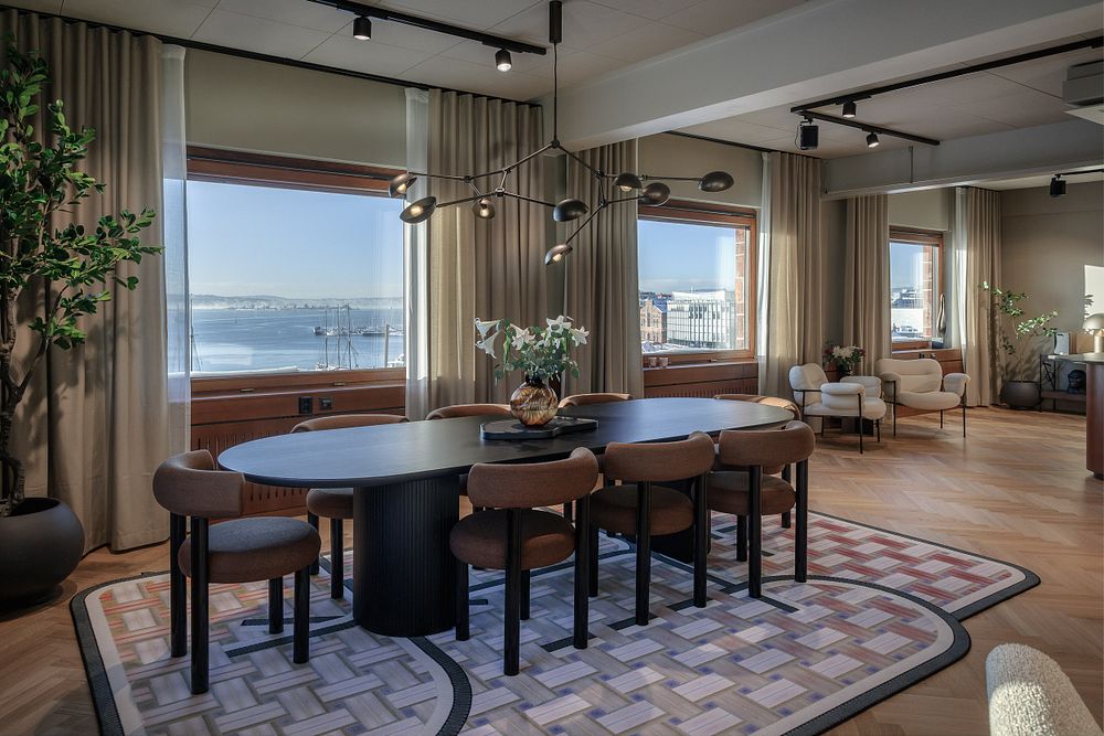 Et rom med vinduer og bord og stoler